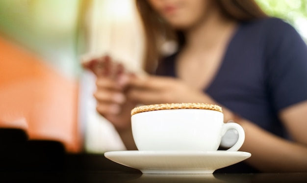 stroopwaffle sur la tasse de café chaud et flou femme