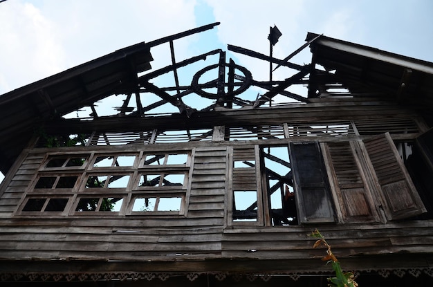 Structure extérieure cassée endommagée d'un bâtiment antique en bois abandonné en plein air provenant d'un vieux feu de maison en bois dans un village de Bangkok en Thaïlande