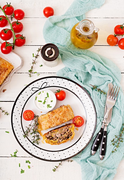 Strudel appétissant avec du boeuf haché, des oignons et des herbes. Mise à plat. Vue de dessus