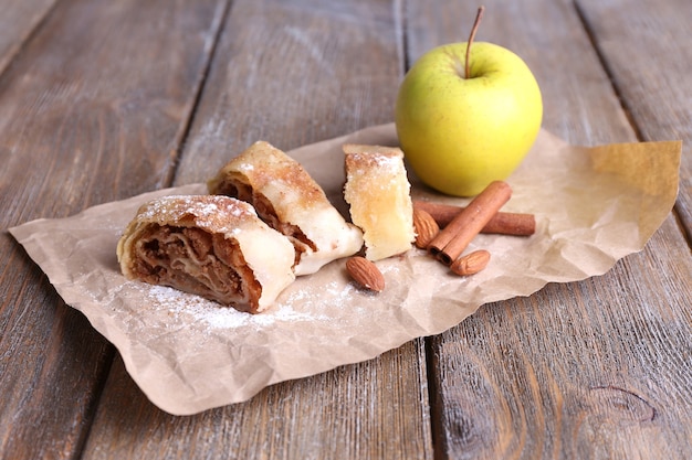 Strudel aux pommes maison savoureux sur une serviette en papier, sur fond de bois