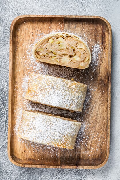 Strudel aux pommes maison traditionnel sur un plateau en bois