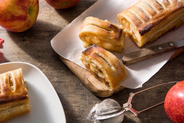 Strudel aux pommes maison traditionnelle sur une table en bois.