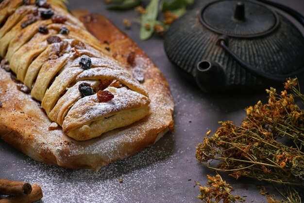 Strudel aux pommes avec sucre en poudre et théière