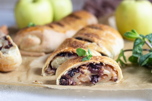 Strudel aux pommes traditionnel avec raisins secs et cannelle sur béton gris