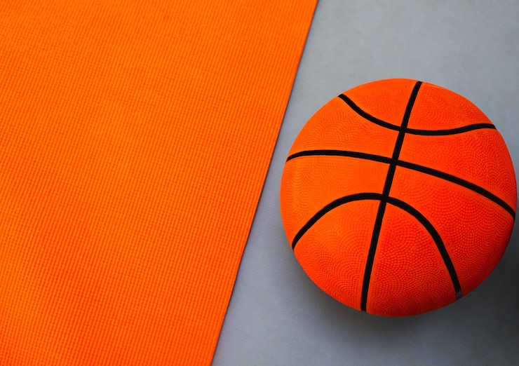 Photo studio d'équipement et basket-ball pour le sport ou le jeu fitness et l'entraînement pour la compétition ou le match ballon arrière-plan orange et gris pour l'activité sportive ou le tournoi pratique et développement des compétences