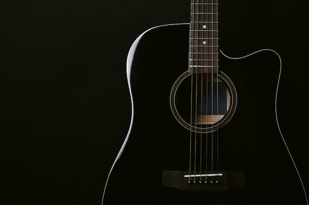 Studio de guitare acoustique noir tourné sur fond noir