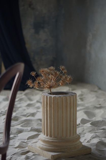 Studio photo avec du sable Un vieux bâtiment abandonné Vase avec des fleurs séchées