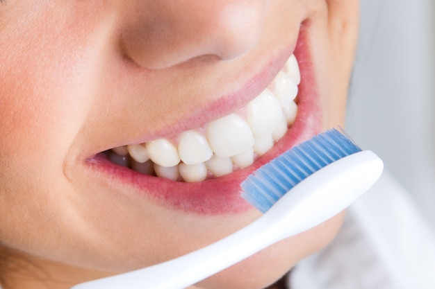 Studio Portrait de belle jeune femme posant avec une brosse à dents