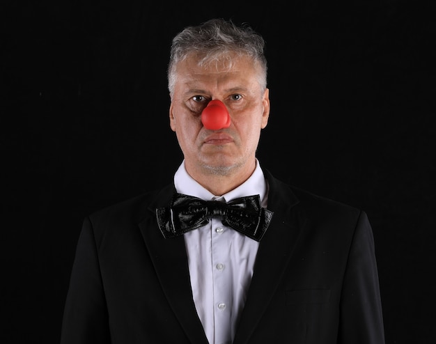 Studio portrait sombre d'un homme au nez rouge