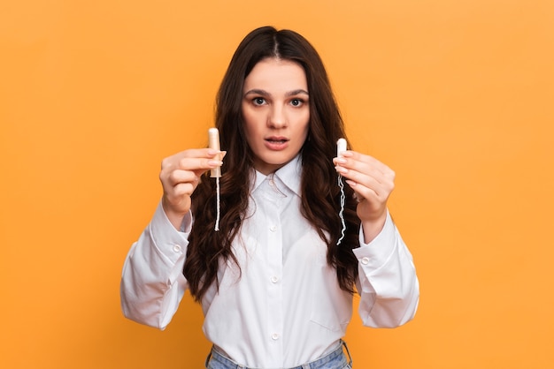 Un studio shot d'une jeune fille tenant un tampon dans un applicateur dans une main, et un tampon