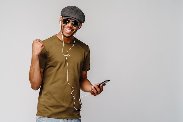 Studio tourné jeune homme afro-américain, écouter de la musique avec des écouteurs