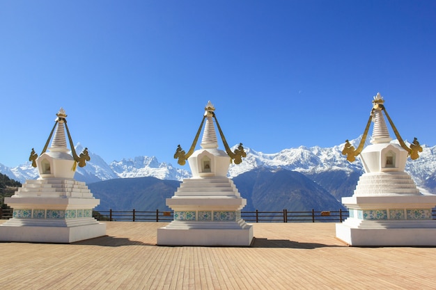 Photo stupas blancs saints par feilai temple surplombant la montagne enneigée meili à deqin yunnan chine