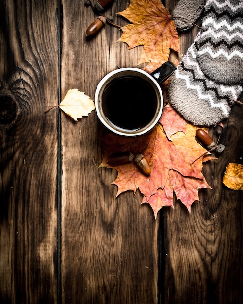 Style d'automne une tasse de café chaud avec des mitaines sur une table en bois