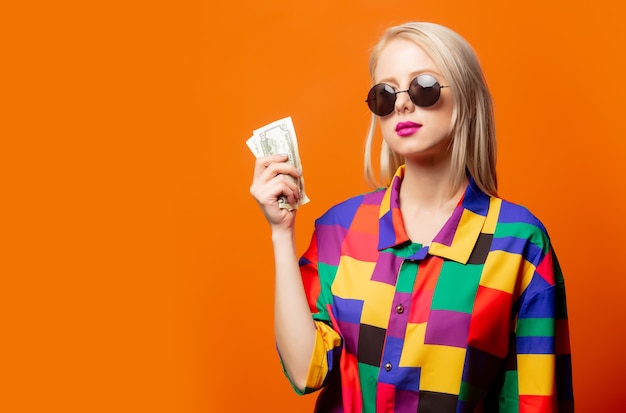 Style blonde en chemise des années 90 avec des dollars sur orange