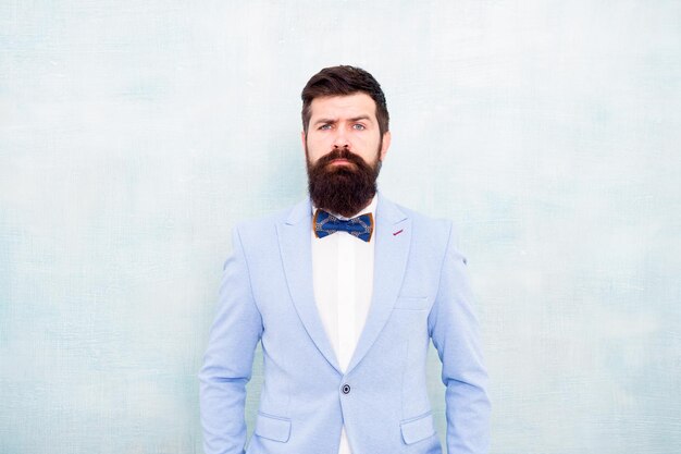 Style de costume Tendances de la mode pour le marié Le marié hipster barbu porte un smoking bleu clair et un nœud papillon Le jour du mariage Le marié élégant Déclaration avec sa superbe veste de costume impeccable Styliste expert de la mode