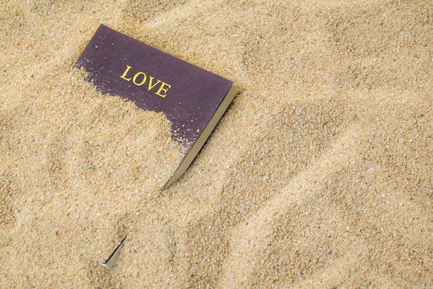 Style d'été avec livre de mémoire d'amour sur un fond de sable de mer pour ajouter un message texte