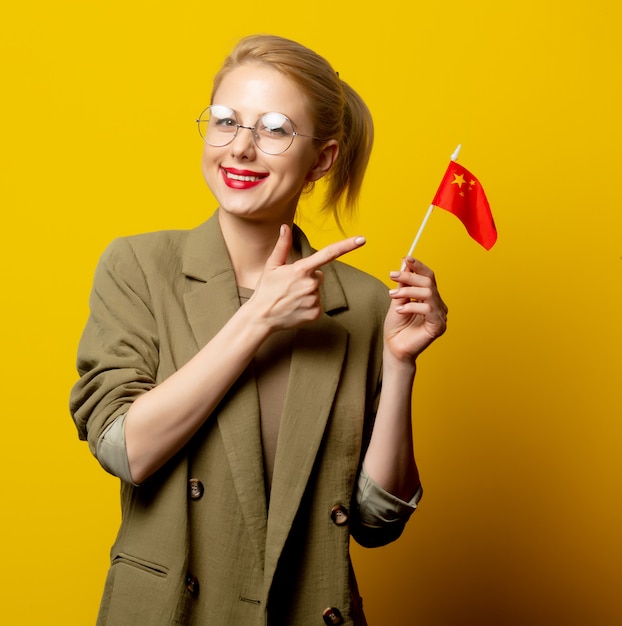 Style femme blonde en veste avec drapeau chinois sur jaune