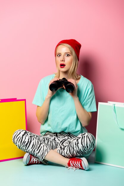 Photo style femme avec des sacs à provisions et des jumelles