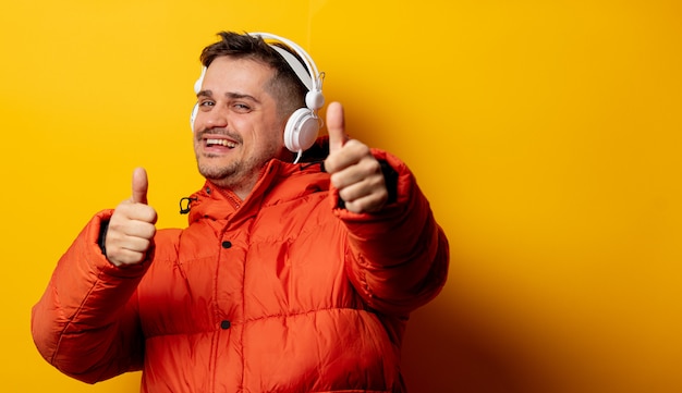 Style homme en veste des années 90 avec un casque sur le mur jaune