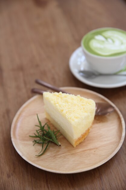 Style japonais de gâteau au fromage avec du thé vert sur le fond en bois