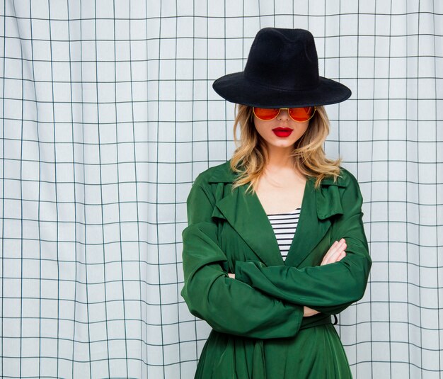 Style jeune femme à lunettes et manteau vert dans le style des années 90