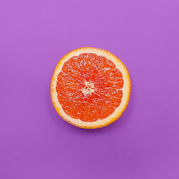 Style minimaliste, mise en page créative orange et pamplemousse sur fond violet