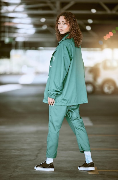 Style de mode et femme dans un parking urbain posant dans des vêtements élégants à la mode et de créateurs Créative à la mode et jeune femme noire dans un parking ou un garage de la ville avec confiance dans une tenue moderne