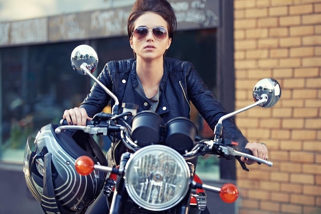 Style moto Photo d'une jeune et élégante motocycliste féminine à l'extérieur