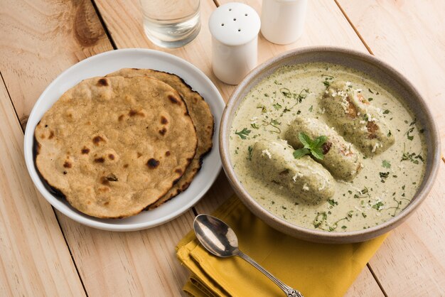 Style Mughlai ou Haryanvi Methi Malai Kofta en crème blanche, plat principal végétarien indien populaire servi dans un bol en bois avec Chapati ou Roti, mise au point sélective