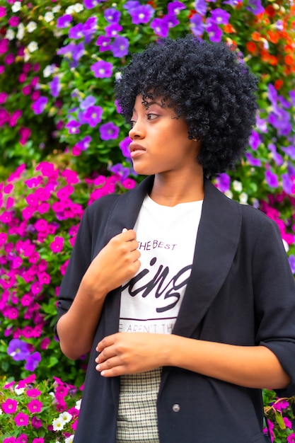 Style de rue, fille dominicaine aux cheveux afro dans certaines fleurs de la ville