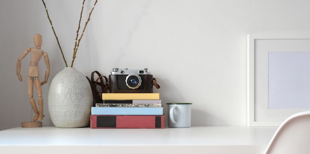 Style de travail minimal avec des fournitures de bureau et des décorations sur un bureau blanc et un mur blanc