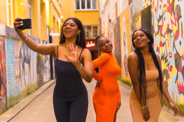 Style urbain à la mode avec trois filles africaines noires dans une rue de la ville