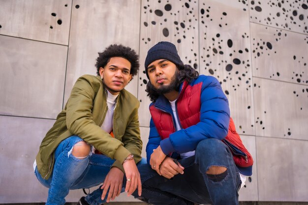 Photo style urbain, portrait de deux amis noirs latinos s'amusant dans la rue.