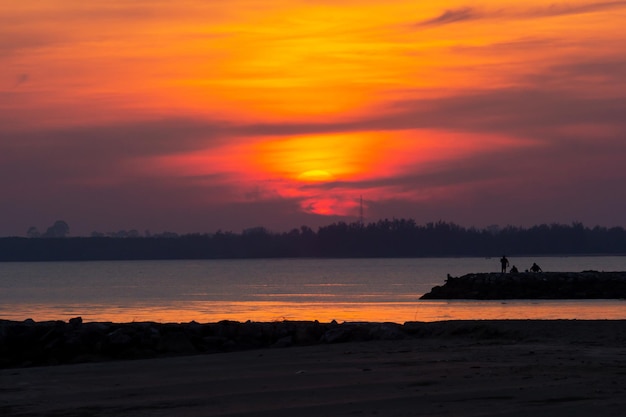 Styles libres de silhouette de plage au coucher du soleil dans le ciel et les gens de l'eau de vacances