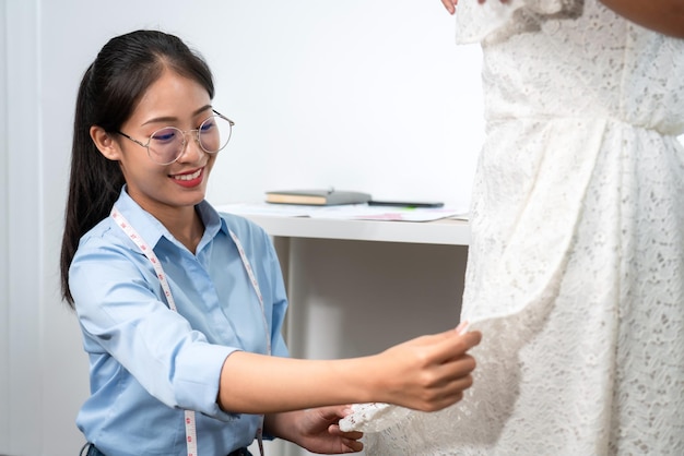 Photo styliste de créateurs de mode pour femmes travaillant et mesurant le tissu en choisissant des échantillons de couleurs pour fabriquer un nouveau produit de collection de vêtements