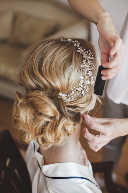 Un styliste fait des cheveux à la mariée