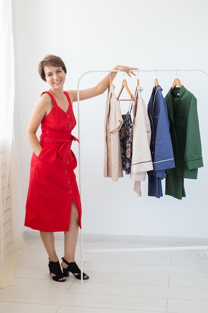 Styliste féminine près du rack avec des cintres. Concept de magasinage, créateur de vêtements et consumérisme.