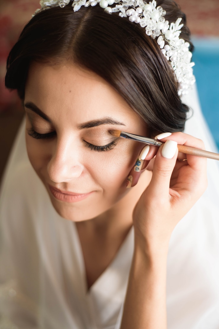 Photo le styliste maquille la mariée le jour du mariage.