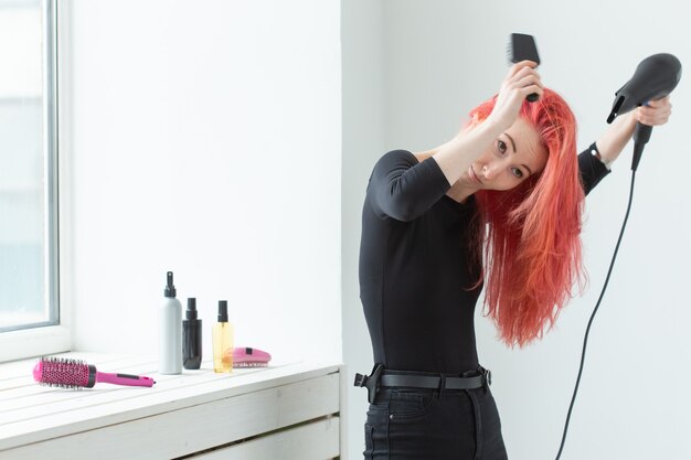 Styliste, mode, coiffeur, concept de personnes - femme séchant ses cheveux colorés.