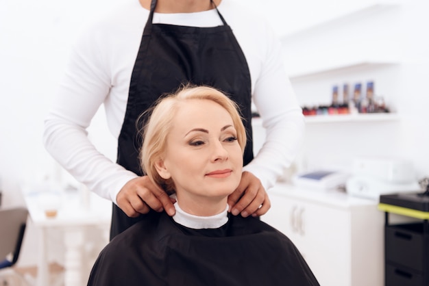 Styliste robes col de coiffure sur le cou de la femme mature.