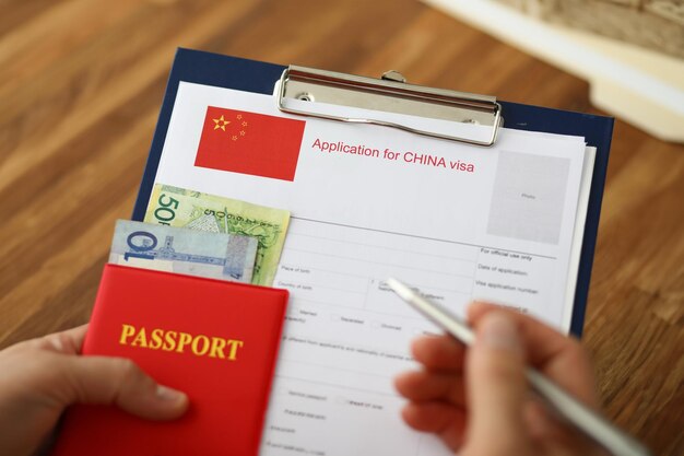 Stylo argenté à main mâle avec passeport remplissant le concept de formulaire d'application en Chine