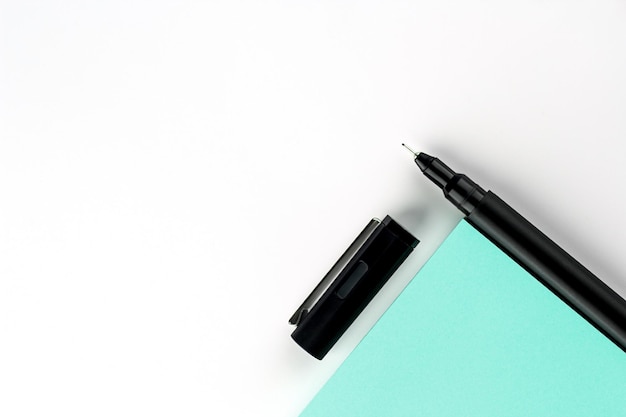 Photo un stylo avec des autocollants turquoise sur un fond blanc