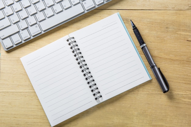 Stylo à bille conceptuel, notes propres de spirale, clavier d&#39;ordinateur sur le dessus de la table en bois.