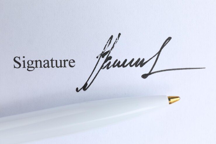 Photo le stylo à bille et la signature sur le contrat
