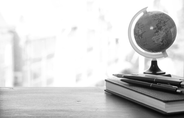 Un stylo sur le bureau et un petit globe bleu