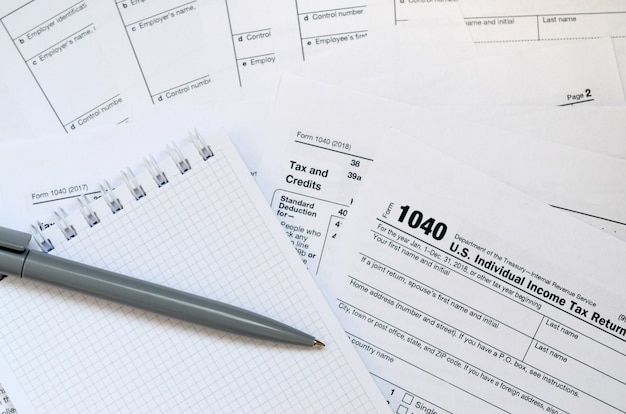 Le stylo et le cahier se trouvent sur le formulaire fiscal 1040 Déclaration de revenus des particuliers américains. Le temps de payer des impôts