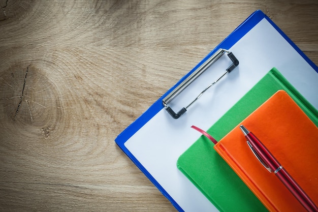 Stylo de cahiers presse-papiers sur planche de bois