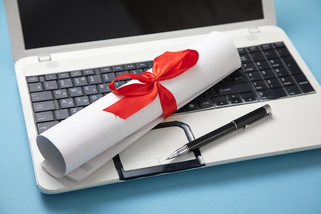 Stylo diplôme sur le clavier de l'ordinateur portable