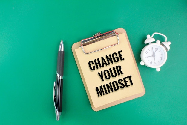 un stylo et du papier avec les mots CHANGE YOUR MINDSET