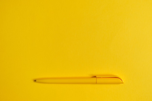 Stylo jaune avec espace copie sur papier jaune.